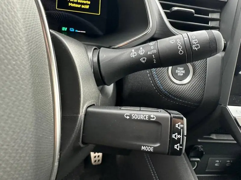Gros plan sur les commandes au volant du Renault Captur 2026 gris Rafale/Noir Étoilé avec bouton start/stop visible.