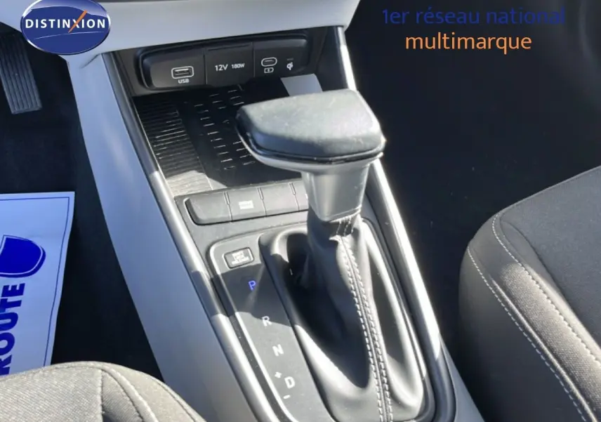 Gros plan sur la console centrale de la Hyundai i20 2025, montrant le levier de vitesse automatique et les ports USB en finition gris aurora metal.