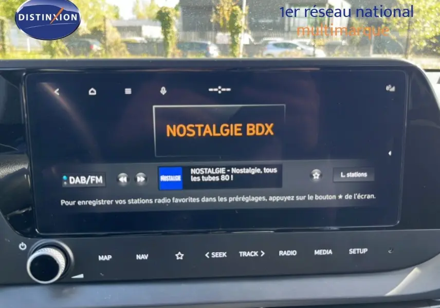 Vue rapprochée de l’écran tactile intérieur d’une Hyundai i20 2025 gris Aurora Metal affichant la radio Nostalgie BDX.