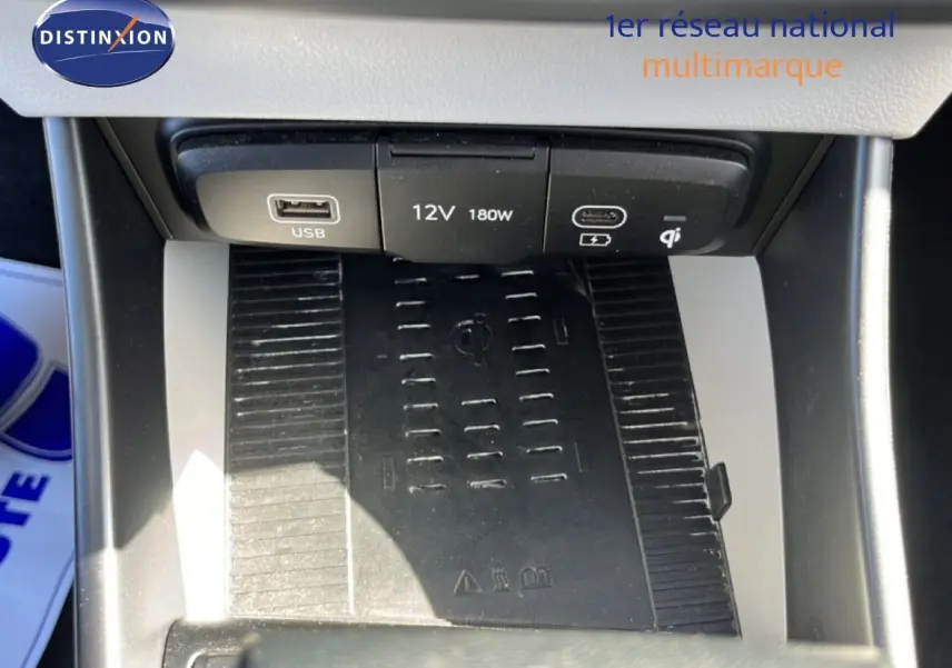 Gros plan sur la console centrale de la Hyundai i20 2025, montrant le chargeur sans fil et les ports USB et 12V.