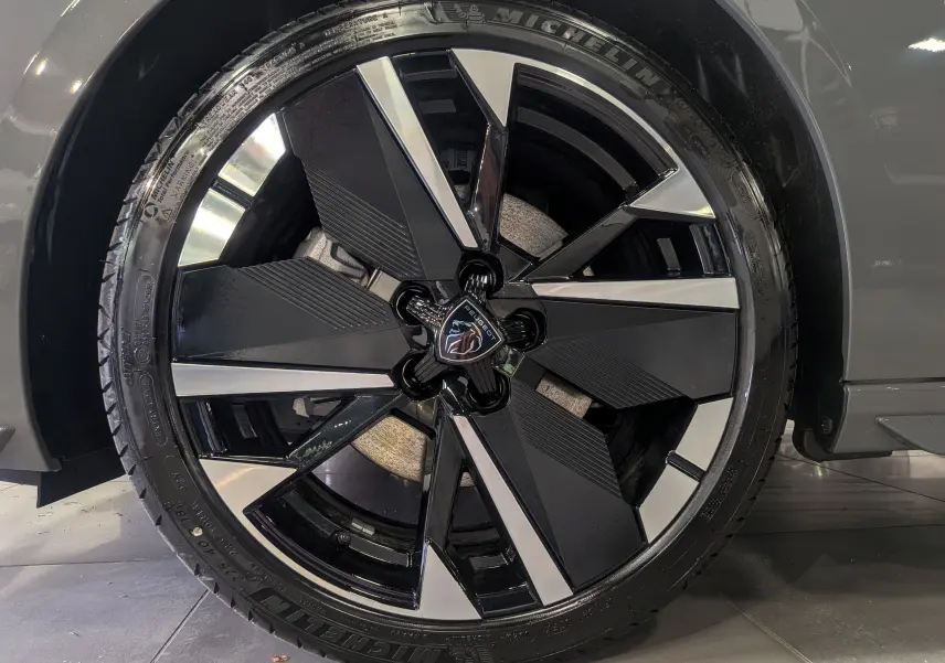 Gros plan sur la jante avant droite bicolore noire et argent de la Peugeot 308 Gris Sélénium 2026.