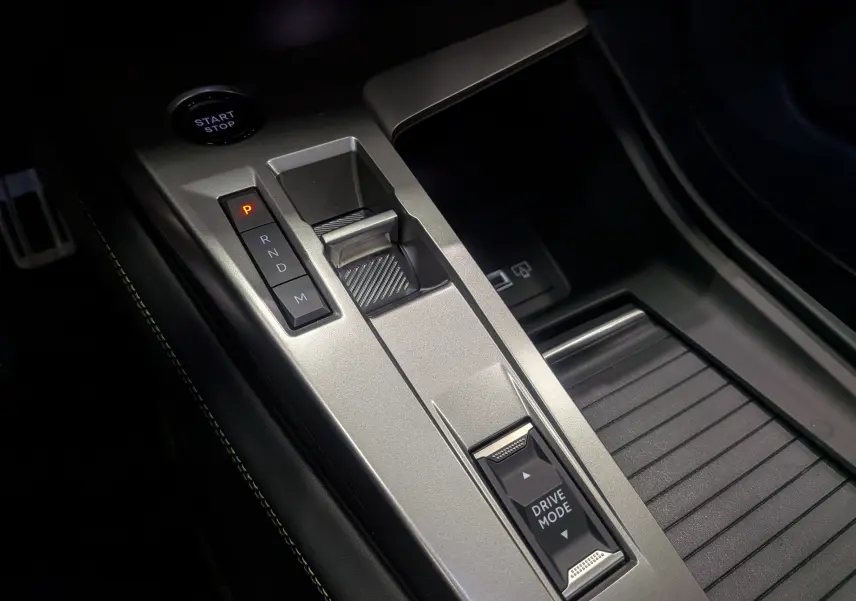 Vue rapprochée de la console centrale grise avec sélecteur de boîte auto et bouton Drive Mode sur Peugeot 308 2026.
