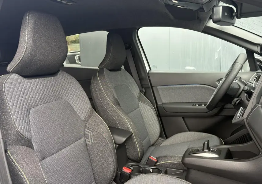 Vue intérieure côté droit du Renault Captur 2026, sièges tissu gris avec coutures contrastantes et console centrale.