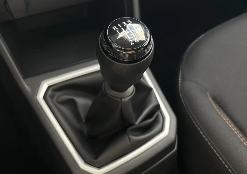 Le levier de vitesse manuel noir de la Dacia Sandero Stepway 2025 avec coutures marron sur siège côté droit.