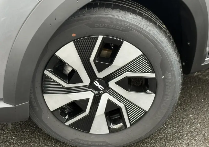Gros plan sur la roue avant droite du Dacia Sandero Stepway gris schiste avec jante Atara Dark 16 pouces.