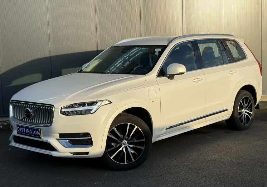 Vue 3/4 avant droite du Volvo XC90 blanc Crystal avec jantes alliage noires et chrome autour des vitres.