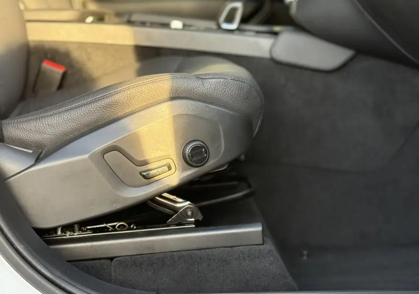 Détail du réglage électrique du siège avant en cuir noir du Volvo XC90 T8 hybride blanc, côté gauche.