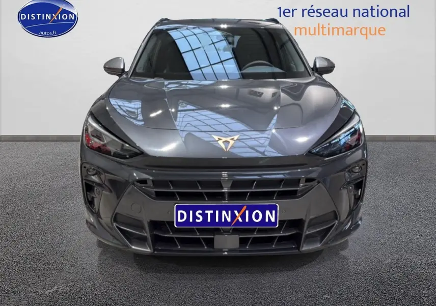 Vue frontale d'une CUPRA Terramar gris métallisé avec calandre large et logo distinctif doré sur le capot.