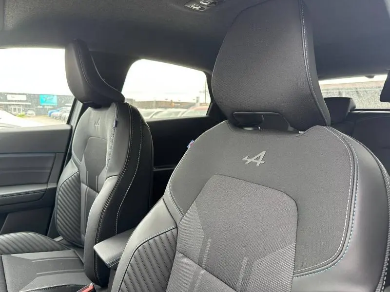 Vue intérieure rapprochée des sièges avant gris avec logo Alpine sur un Renault Captur 2026 esprit Alpine.