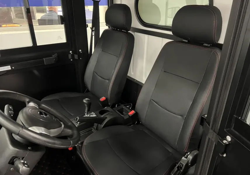 Vue intérieure côté conducteur du Liberty L7e H2 Cargo 2025, sièges noirs avec surpiqûres rouges et volant 3 branches.
