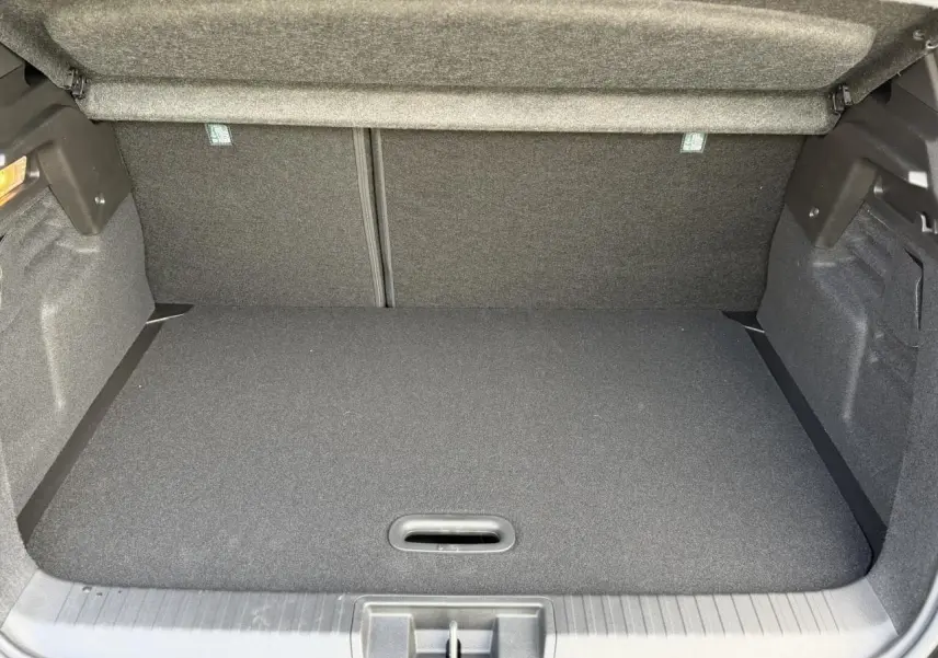 Coffre ouvert du Renault Captur noir étoile, vue intérieure montrant le plancher de coffre mobile et espace de rangement.