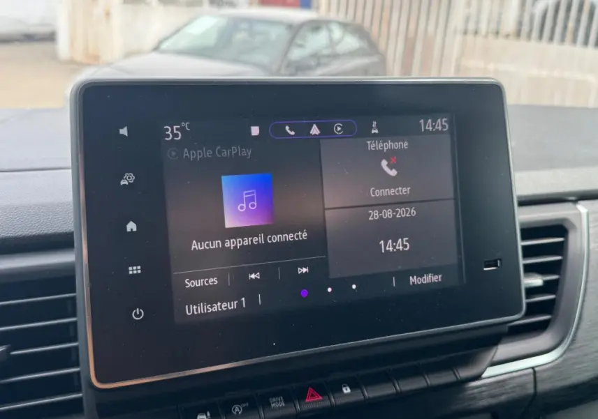 Vue rapprochée de l’écran tactile central du Renault Trafic Fourgon gris foncé, affichant l’interface Apple CarPlay.