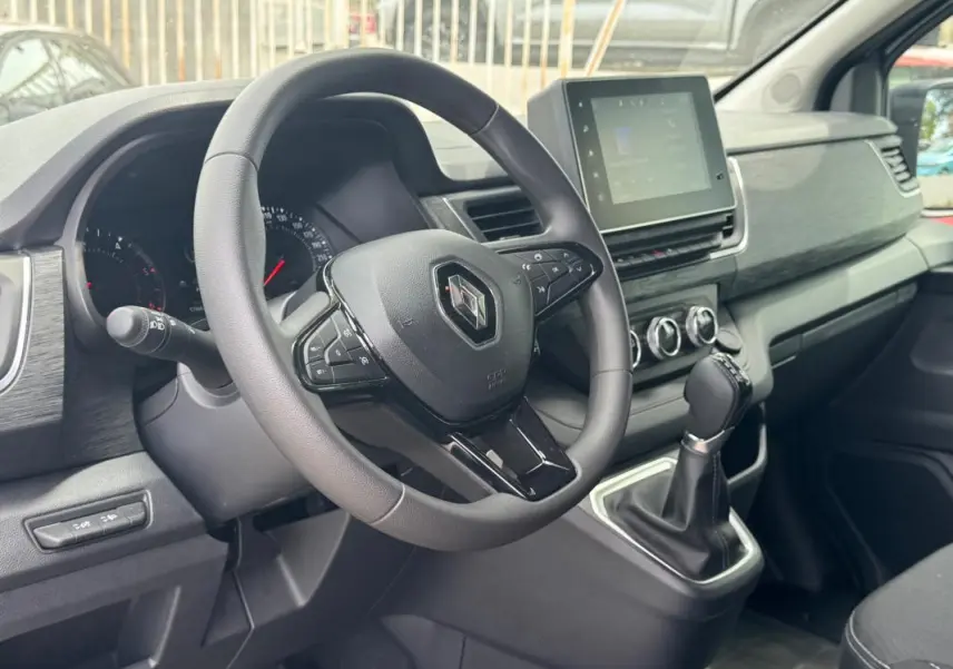 Vue intérieure côté conducteur du Renault Trafic Fourgon 2024, montrant le volant, tableau de bord et écran tactile.