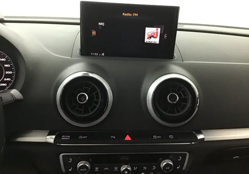 Tableau de bord noir d'Audi A3 Cabriolet 2020 avec écran central et aérateurs ronds chromés vus de face.