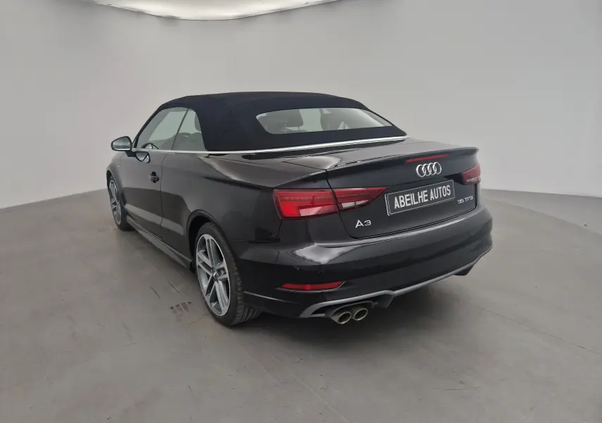 Audi A3 Cabriolet noir vue 3/4 arrière droit avec capote en toile fermée et double sortie d'échappement chrome.
