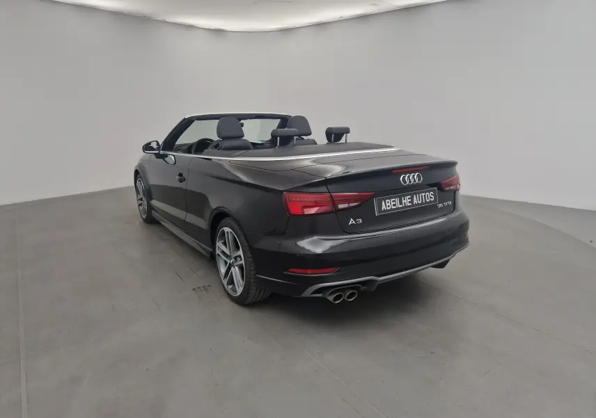 Audi A3 Cabriolet noir vue 3/4 arrière droit avec capote électrique et double sortie d'échappement chrome.