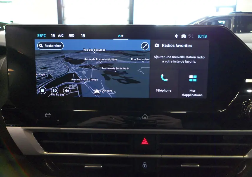 Écran tactile central du tableau de bord du Citroën C4 Hybride 2025 affichant la navigation et les options radio.