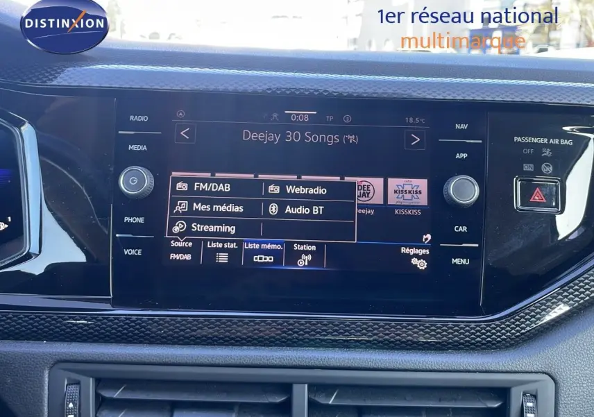 Écran tactile central du tableau de bord du Volkswagen Taigo gris cendre, affichant les options radio et streaming.