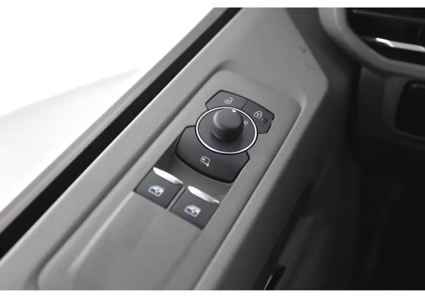 Gros plan sur les commandes de réglage des rétroviseurs et vitres côté conducteur du Volkswagen Transporter gris Stone 2025.