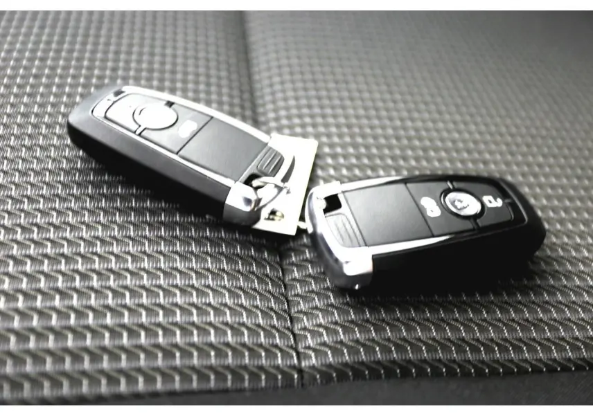 Clé de contact Volkswagen posée sur un siège en tissu à rayures noir du Transporter T7 Business 2025.