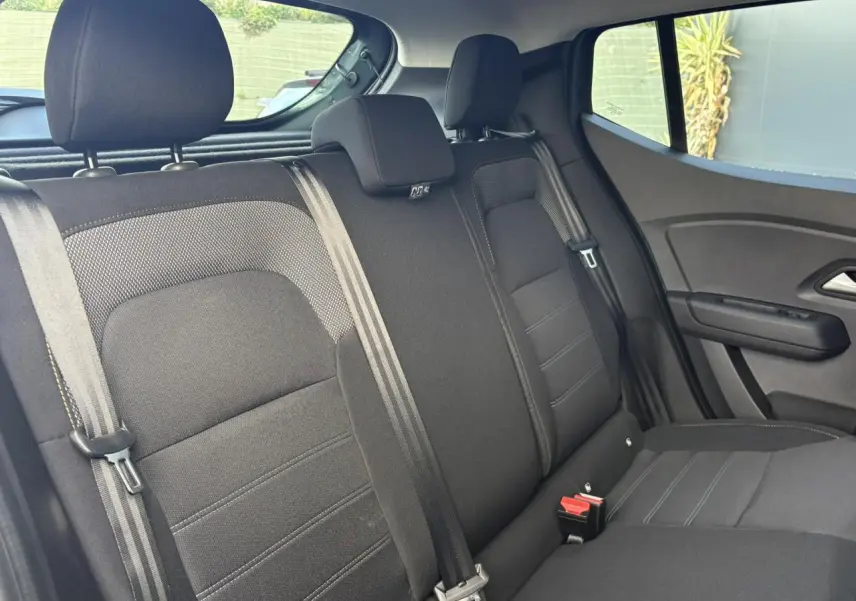 Vue intérieure de la banquette arrière noire du Dacia Sandero Stepway 2025 avec ceintures et appuie-têtes visibles.