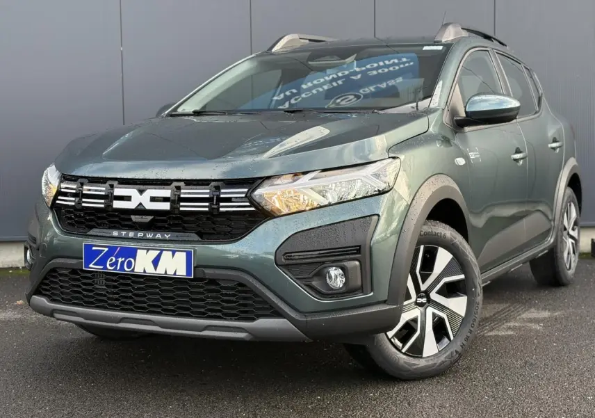 Dacia Sandero Stepway vert cèdre en 3/4 avant droit, avec barres de toit et jantes spécifiques noir et argent.