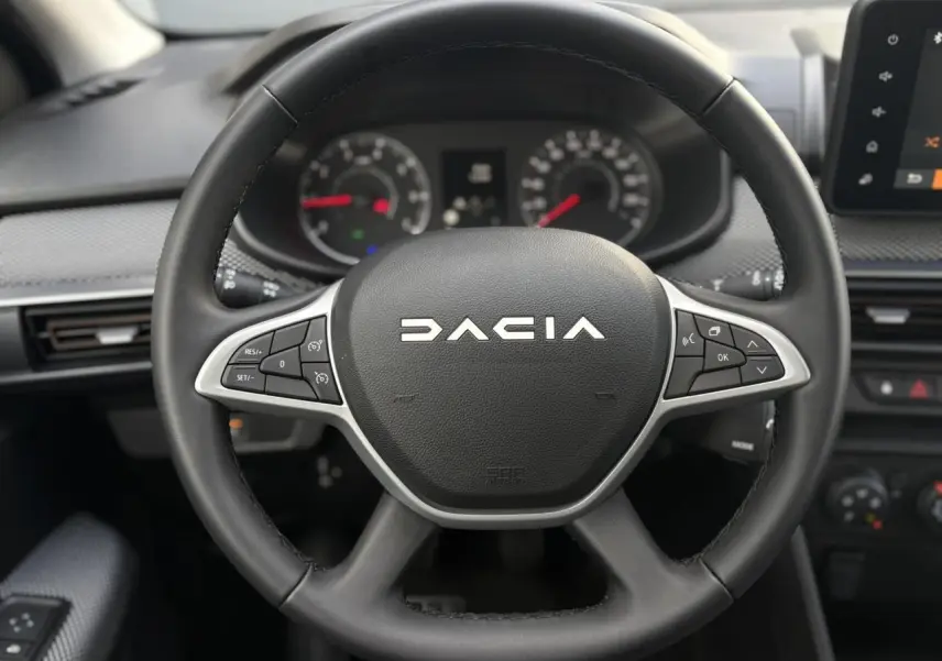 Volant noir de Dacia Sandero Stepway 2025 vu de face, avec commandes intégrées et tableau de bord numérique.