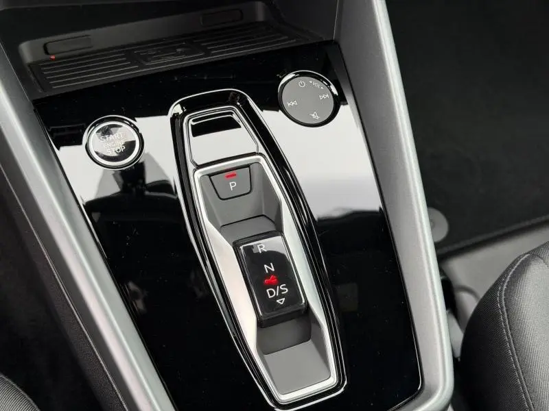 Gros plan sur la console centrale noire brillante de l'Audi A3 Sportback 30 TFSI, avec levier de vitesses automatique et bouton Start/Stop.