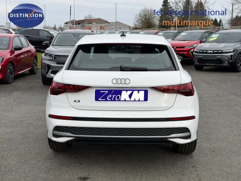 Vue arrière d'une Audi A3 Sportback blanche Arkona 2024, avec feux arrière LED et becquet noir distinctif.