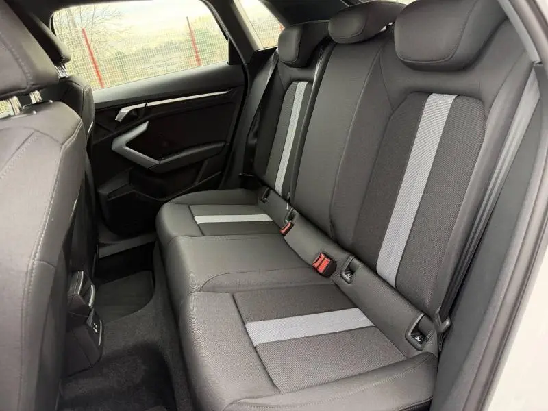 Vue intérieure côté droit de la banquette arrière noire et grise de l'Audi A3 Sportback 30 TFSI Hybride 2024.