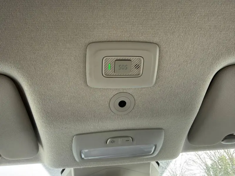 Vue intérieure du plafond avant du Dacia Jogger 2025 avec bouton SOS et éclairage, tissu gris clair.