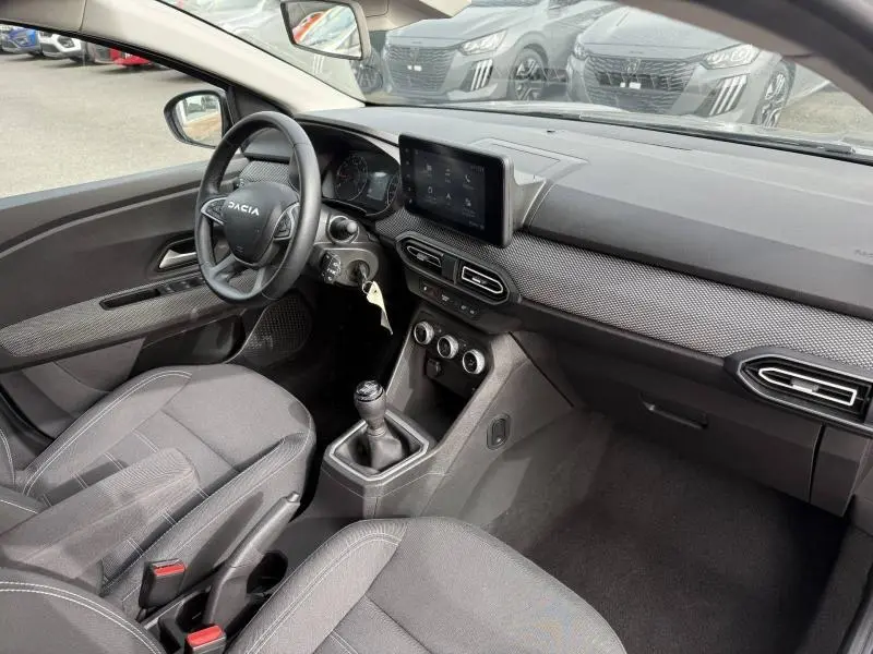 Vue intérieure côté conducteur du Dacia Jogger 2025, tableau de bord moderne avec écran tactile et volant multifonction.