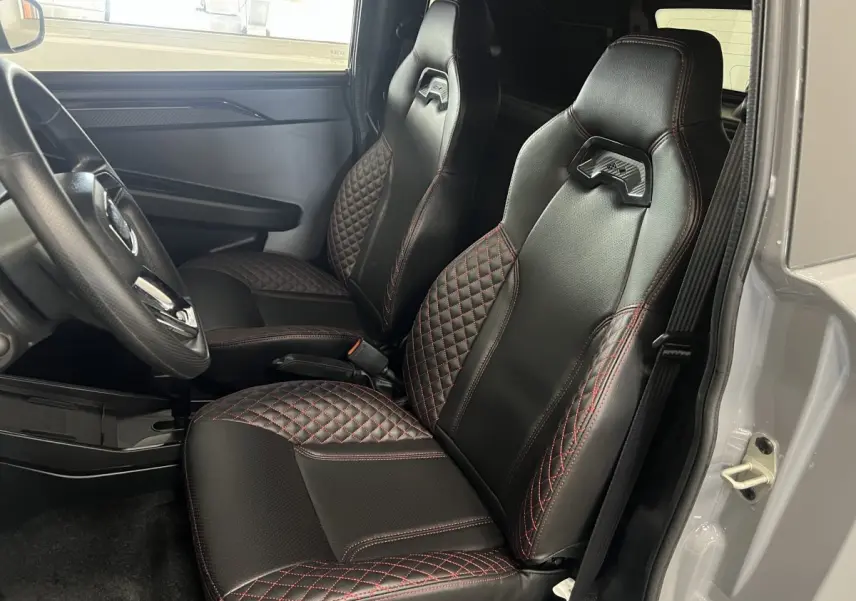 Vue intérieure côté conducteur montrant les sièges noirs avec surpiqûres rouges du Ligier JS50 0.5 REVO D+ Ultimate 2026.
