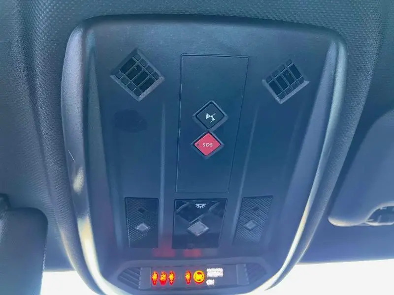 Panneau de commandes au plafond intérieur du DS3 Crossback E-Tense 2021 avec bouton SOS rouge et éclairage LED.