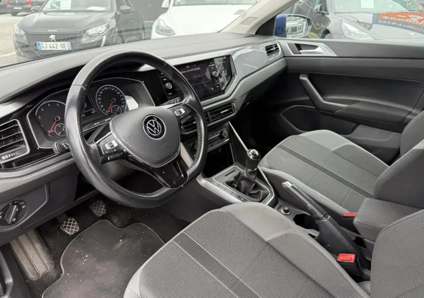 Intérieur avant de Volkswagen Polo 1.0 TSI 2021, siège tissu sport gris et volant trois branches noir.