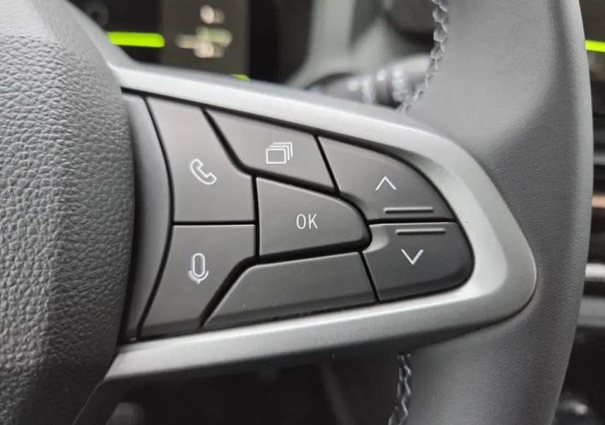 Gros plan sur les commandes au volant côté droit du Dacia Bigster 2025, finition Extreme, intérieur noir.