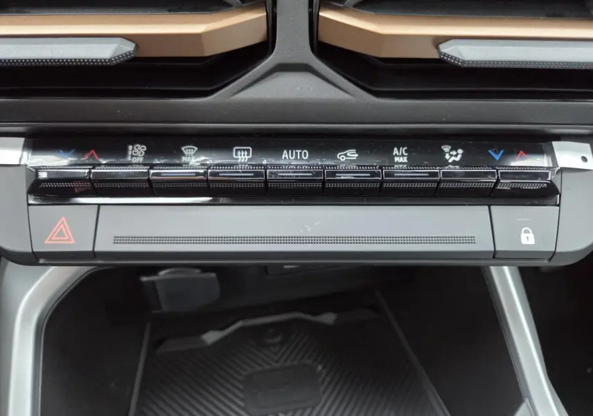 Gros plan sur la console centrale du Dacia Bigster 2025, avec commandes climatisation et détails brun cuivré visibles