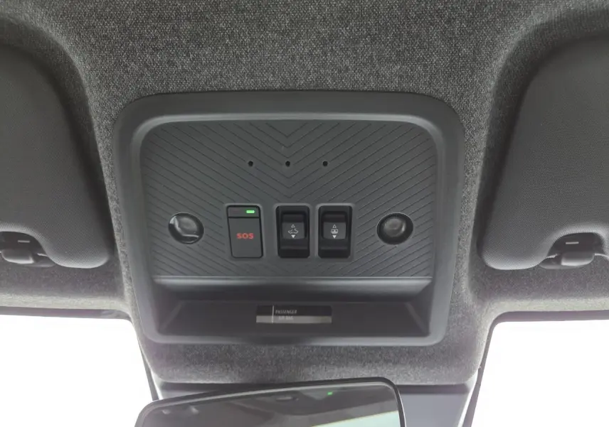 Vue intérieure du plafonnier du Dacia Bigster blanc glacier 2025 avec boutons SOS et commandes toit ouvrant.