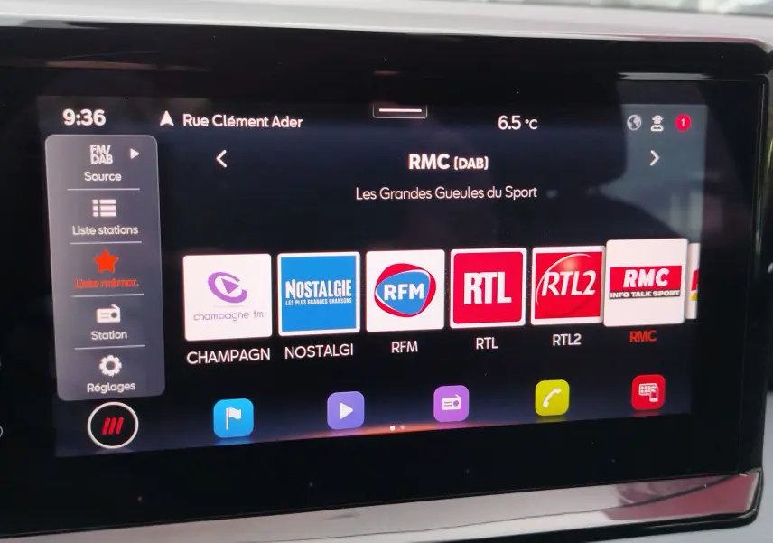 Écran tactile central de la SEAT Arona blanc candy montrant les stations radio numériques en mode DAB.