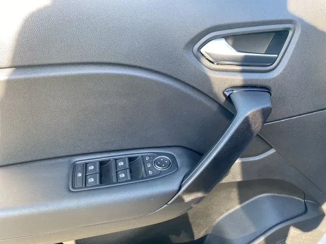 Détail de la porte côté conducteur du Renault Captur gris Cassiopée 2023, avec commandes des vitres et poignée intérieure noire.