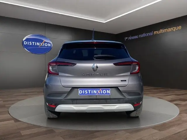 Vue arrière d'un Renault Captur E-Tech Full Hybrid 145 gris Cassiopée, avec feux LED et logo distinctif.