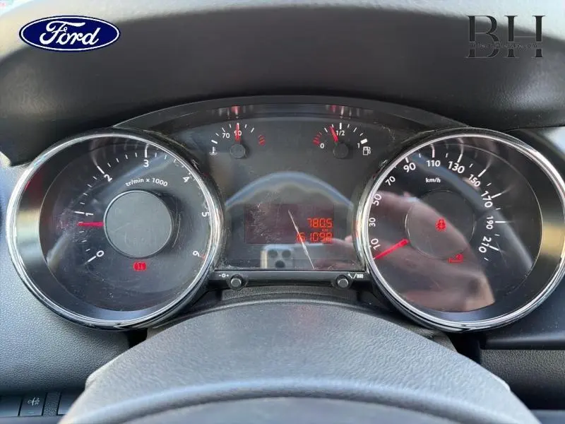 Vue rapprochée du tableau de bord d'un Peugeot 3008 noir, affichant compte-tours, vitesse et indicateurs numériques.