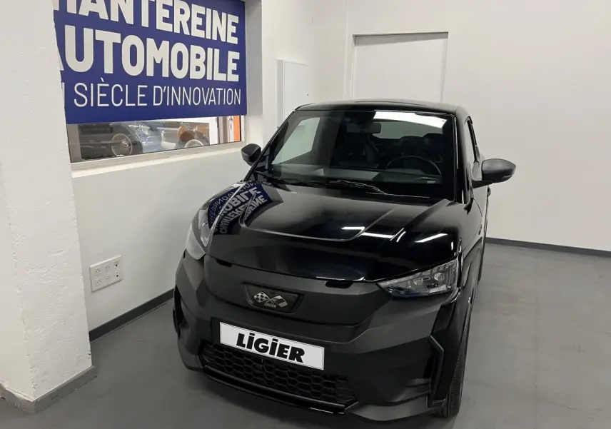 Vue 3/4 avant d'une Ligier JS50 0.5 REVO D+ Ultimate noire, avec calandre noire et phares LED visibles.