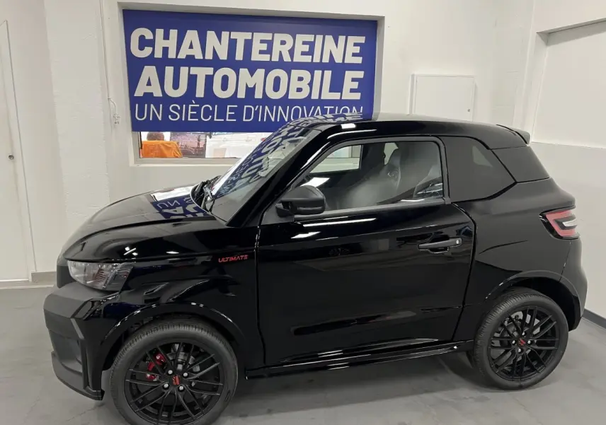 Vue de profil côté gauche d'une Ligier JS50 0.5 REVO D+ ULTIMATE noire avec jantes alu noires mates et badge Ultimate rouge.