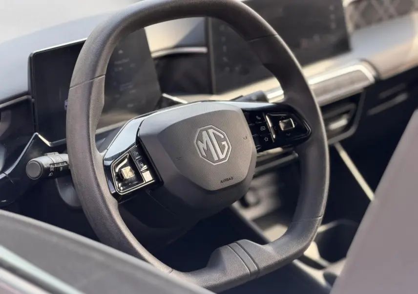 Vue rapprochée du volant noir du MG3 1.5 Hybrid+ 195 Comfort, mettant en valeur le logo MG central et les commandes intégrées.