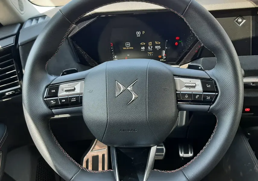 Volant en cuir noir avec logo DS au centre, tableau de bord numérique et commandes intégrées, intérieur DS4 2024.