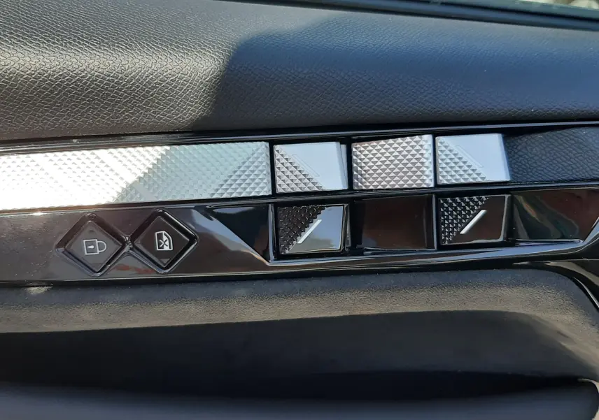 Gros plan sur les commandes de porte en finition noire et argentée du DS4 2024 couleur Cristal Pearl.