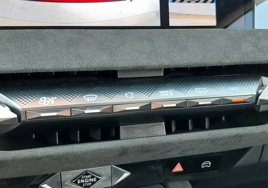 Vue rapprochée de la console centrale du DS4 2024 avec commandes climatisation et bouton start/stop, intérieur noir sophistiqué.