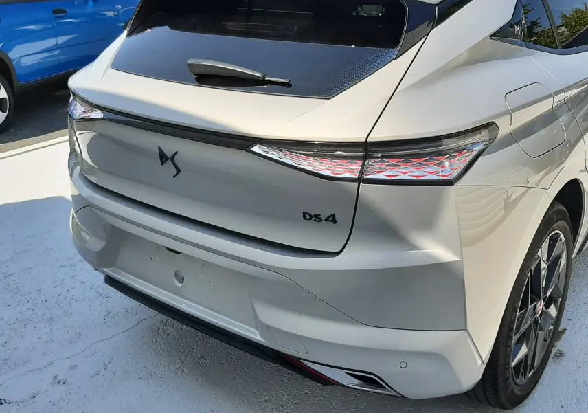 Vue arrière côté droit d'une DS4 2024 Cristal Pearl avec feux arrière LED et lunette arrière teintée.