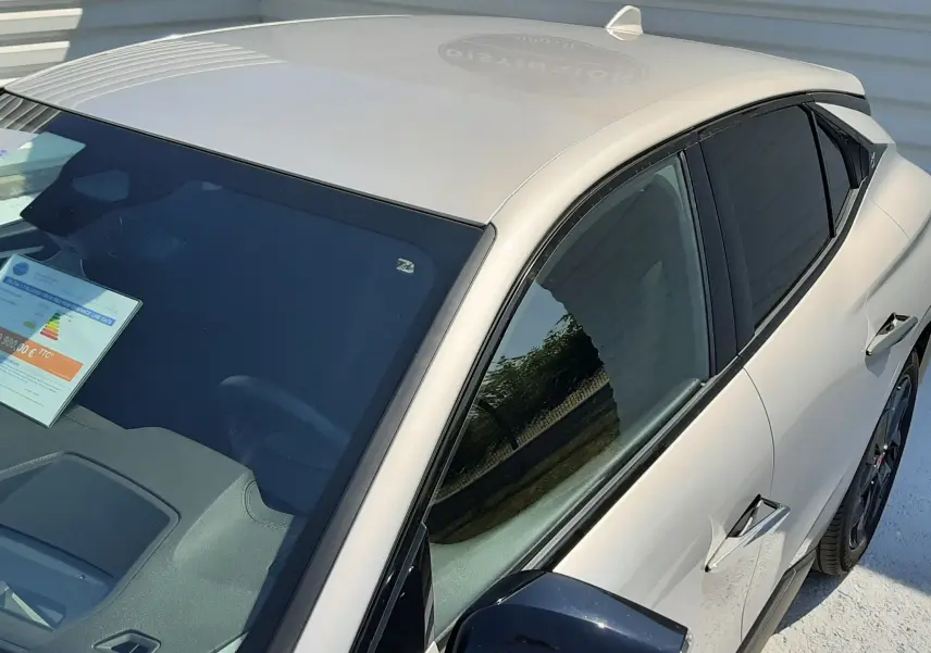 Vue plongeante côté gauche sur DS4 2024 Cristal Pearl avec rétroviseur noir brillant et vitres teintées.